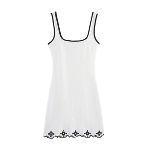 White sleeveless mini dress with black trim and floral embroidery on the wavy hemline
