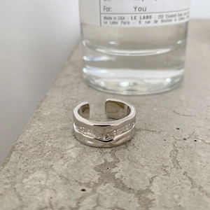 Macro shot of silver adjustable irregular hammered ring texture on stone surface