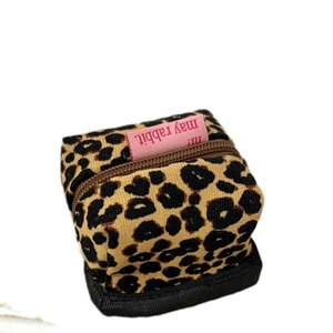 Leopard print corduroy earphone pouch with brown zipper and pink label on white background