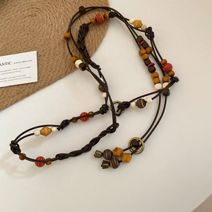 Close-up of Bohemian beaded waist chain with colorful wooden beads and woven brown cord
