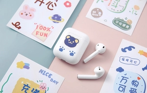 Close-up of cute cartoon bear sticker on white wireless earphone charging case cover