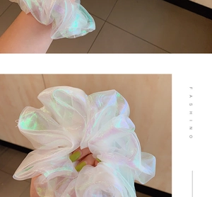Detail of white iridescent organza scrunchie showing luminous texture and fluffy volume