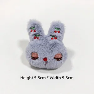 Detail shot of a grey plush rabbit accessory with cherry embroidery, sized 5.5cm x 5.5cm