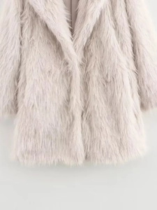 Close-up of soft faux fur texture on light beige stylish women coat for winter