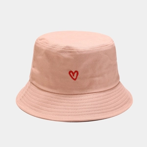 Detailed close-up of heart embroidery on light pink cotton bucket hat with stitching detail