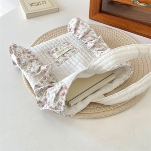 Detail of quilted canvas handbag with floral ruffles showing spacious interior capacity