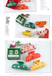 Detailed close-up of colorful Christmas claw clips with festive elk and Santa Claus patterns