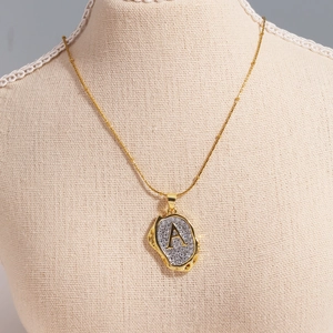 Close-up of gold plated O-chain necklace with sparkling zircon paved letter A pendant