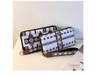 Close-up of geometric pattern long wallets with wrist straps and golden hardware zippers