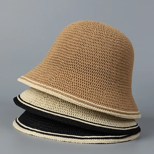 Three knitted straw bucket hats in brown, beige, and black with striped brim details