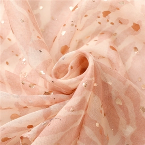 Macro shot of pink fabric with golden dots and elegant ruffled texture detail