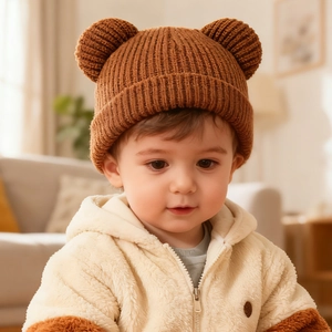 Close-up of caramel brown infant knit hat featuring cute 3D bear ears on soft wool fabric