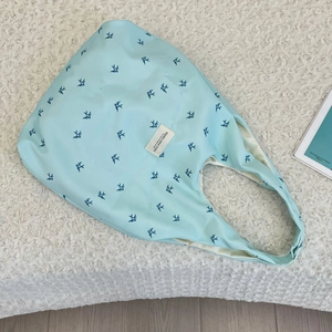 Gros plan du sac cabas en toile bleu clair avec motifs d'hirondelles et étiquette SOZAKKA