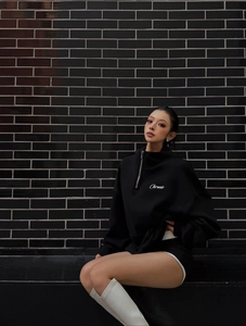 Dettaglio felpa nera oversize con mezza zip e ricamo Chronic bianco sul petto