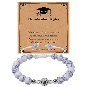 Close-up of natural white turquoise beads with silver compass charm on a graduation gift card