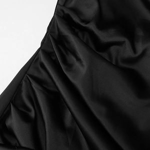 Detail of elegant black satin dress featuring sophisticated ruched pleats and silky texture