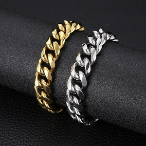 Detailed close-up of gold and silver cuban link bracelets on black display pillars