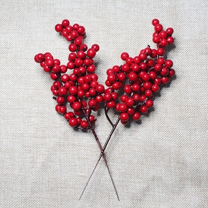 Close-up of bright red artificial berries branches for Christmas wreath decoration