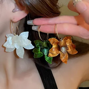 Retro resin flower hoop earrings in white, green, and amber with golden hooks