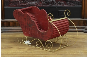 Detail of red wooden Christmas sleigh ornament with gold glitter rails for holiday decor