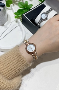 Detailed view of silver and gold flower bezel quartz watches on marble tray