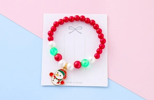 Close-up of children's Christmas bead bracelet featuring a cute enamel snowman charm