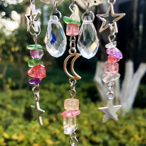 Detail of suncatcher with metal moon, stars, crystals and colorful stones in sunlight