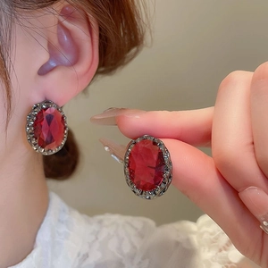 Vintage oval red zircon earrings with dark metal hollow frame shown on a model