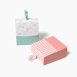 Mini floral and checkered lipstick gift boxes with ribbon handles on white background