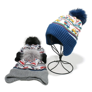 Winter knit baby hats with pom-poms featuring construction truck patterns and earflaps