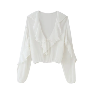 Close-up of white long-sleeved shirt with ruffle V-neckline and tie-front detail
