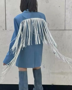 Detailed back view of a blue wool blazer with long white decorative fringe accents