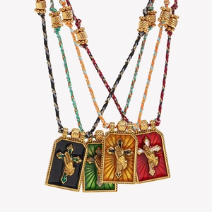 Macro view of 18K gold tarot necklaces with colorful enamel cross pendants