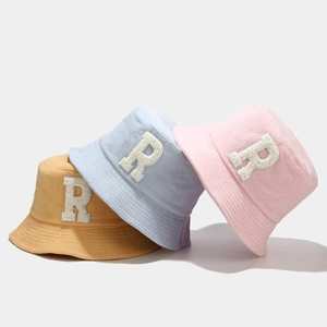 Detailed close-up of colorful bucket hats featuring plush R letter embroidery design