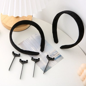 Ensemble de serre-têtes noirs floqués avec supports en plastique sur une table blanche