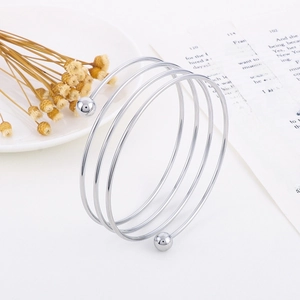 Minimalist multi-layer stainless steel wrap bracelet with beads on white ceramic plate
