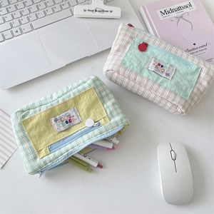 Close-up of cute checkered canvas pencil cases with multi-layer pockets on a desk