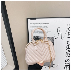 Close-up of nude pink jelly shell bag with V-quilted texture and gold chain link