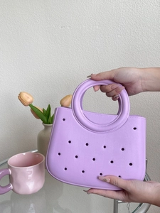 Vue détaillée d'un sac de plage en EVA violet avec des trous décoratifs et des poignées