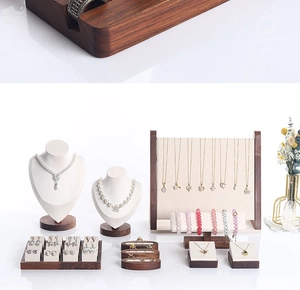 Detailed set of walnut wood jewelry displays with beige velvet lining for necklaces and rings