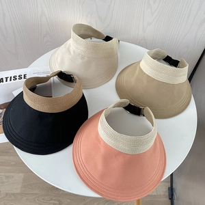 Detail of straw sun visors in black, pink, cream, and khaki with adjustable straps