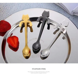 Three creative cat-shaped stainless steel spoons hanging on a tray for coffee and dessert