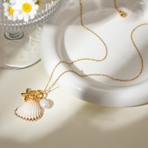 Collana francese con conchiglia di mare, stella marina, perla e catena d'oro su piatto