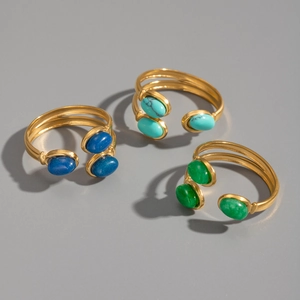 Vue détaillée de trois bagues dorées avec des pierres ovales bleues, turquoises et vertes