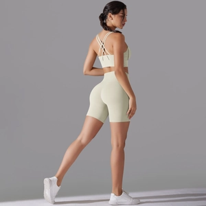 Dettaglio degli shorts da yoga a vita alta e reggiseno sportivo incrociato color beige
