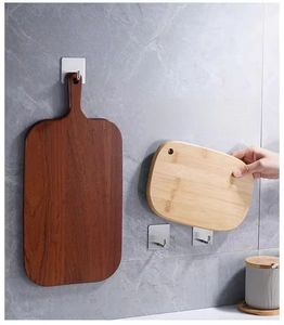 Strong stainless steel adhesive hooks holding wooden cutting boards on a kitchen wall