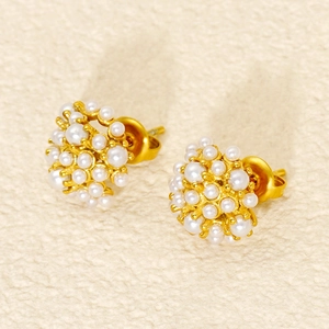 Macro shot of 18k gold pearl stud earrings with a round cluster of tiny pearls