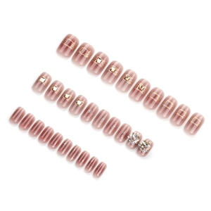 Kit 30 faux ongles nude dégradé avec lignes dorées, strass et perles sur blanc
