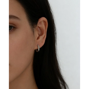 Macro detail of S925 silver earring with marquise zircon on a model's ear
