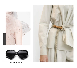 Close-up of heart-shaped black polarized sunglasses with pink lace top and woven belt
